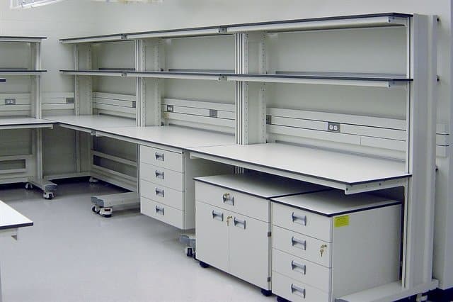 white lab furniture with undercounter storage and wall shelves.