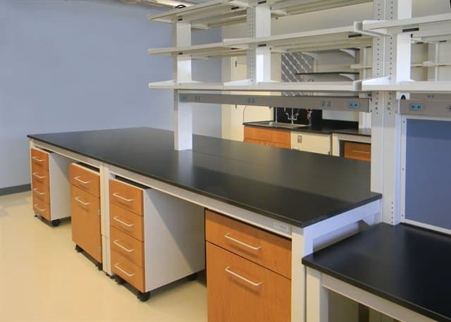 Lab tables with dark surfaces and portable undercounter storage